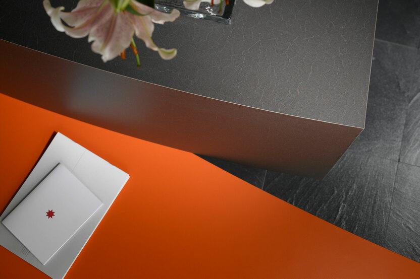 Detailaufnahme einer Empfangstheke mit verschiedener Lackierung Detailaufnahme einer Empfangstheke mit Kontrast-Lackierung in Schwarz und Orange