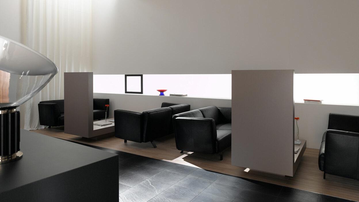 Hotellobby mit Trennwänden aus Holz Hotellobby mit Trennwänden aus Holz und schwarzen Ledersofas