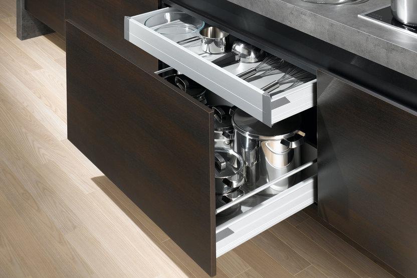 Detailaufnahme von Küchenschubladen mit viel Stauraum in dunklem Holz