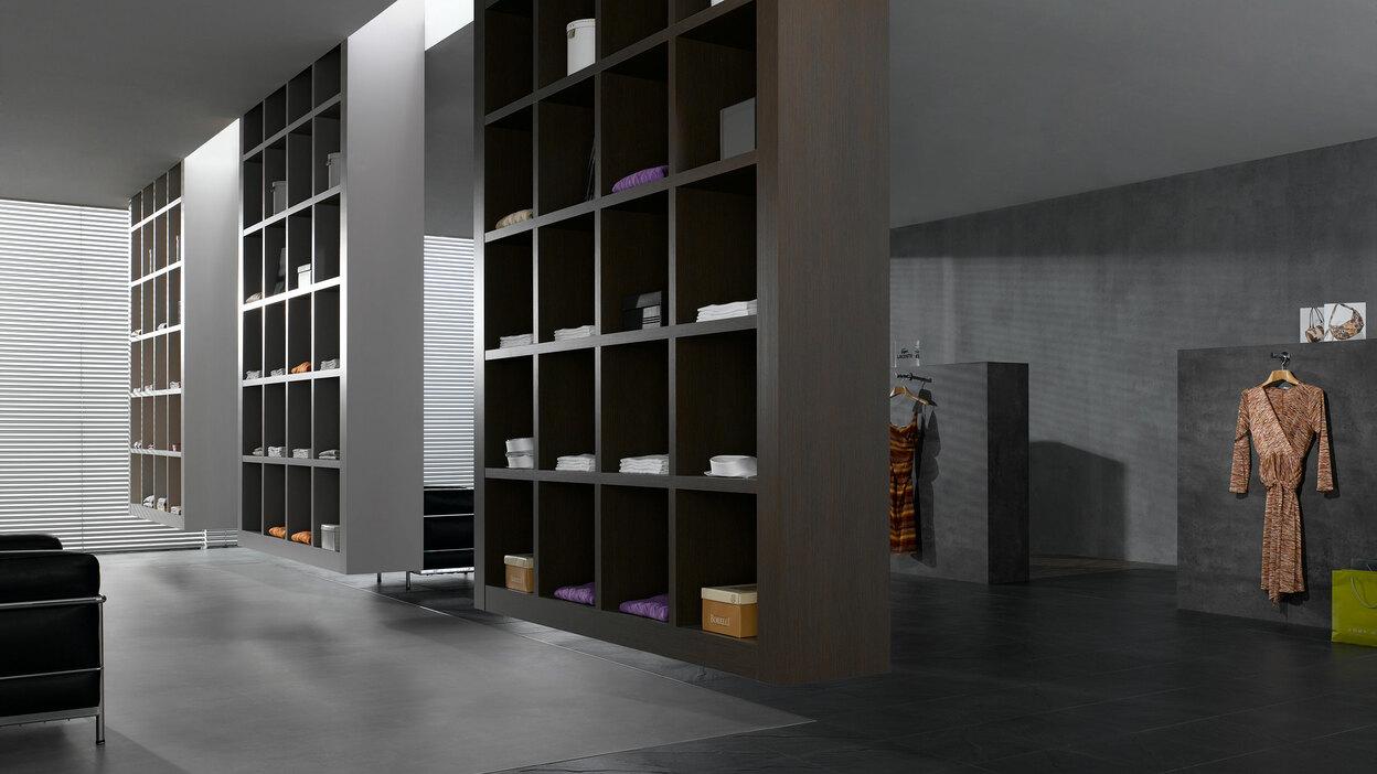 Impression eines Regalsystems in einem Bekleidungsladen Impression eines geräumigen Regalsystems aus dunklem Holz in einem hochwertigen Bekleidungsladen